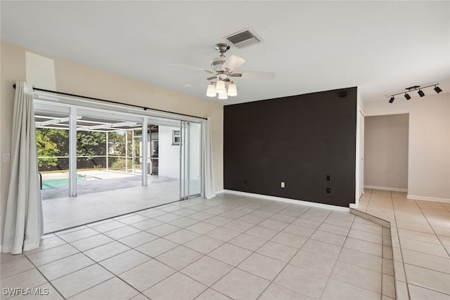 unfurnished room with rail lighting, ceiling fan, and light tile patterned floors