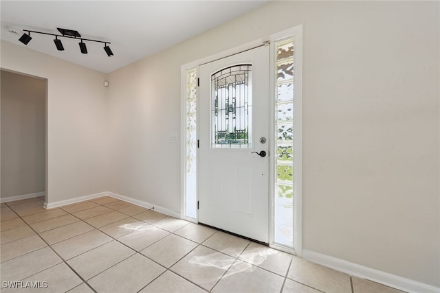 foyer entrance with light tile patterned flooring and rail lighting