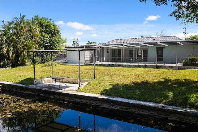 back of property featuring a patio, a yard, and glass enclosure