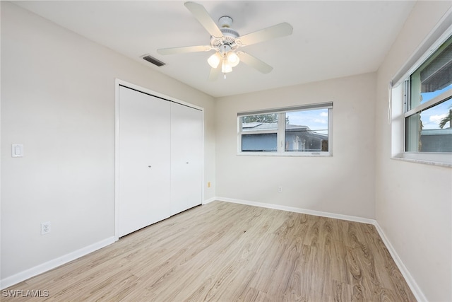 unfurnished bedroom with light hardwood / wood-style floors, a closet, and ceiling fan