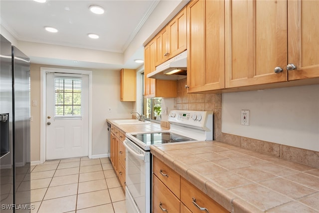 kitchen with electric range, tile countertops, ornamental molding, light tile patterned flooring, and sink