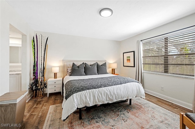 bedroom with ensuite bathroom and wood-type flooring