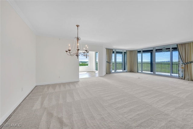 unfurnished living room with ornamental molding, a chandelier, and light colored carpet