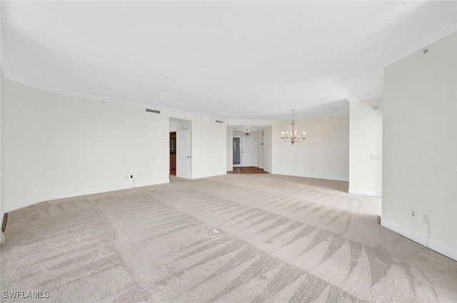 empty room with light carpet and an inviting chandelier