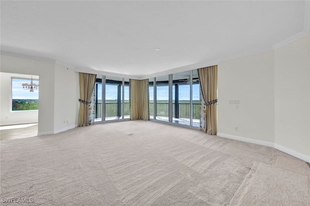 carpeted empty room with ornamental molding and a chandelier