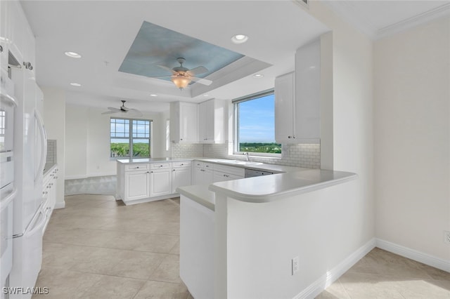 kitchen with kitchen peninsula, white cabinets, a healthy amount of sunlight, and light tile patterned flooring