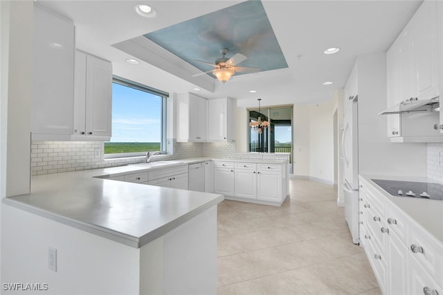 kitchen featuring white cabinetry, kitchen peninsula, and black electric cooktop