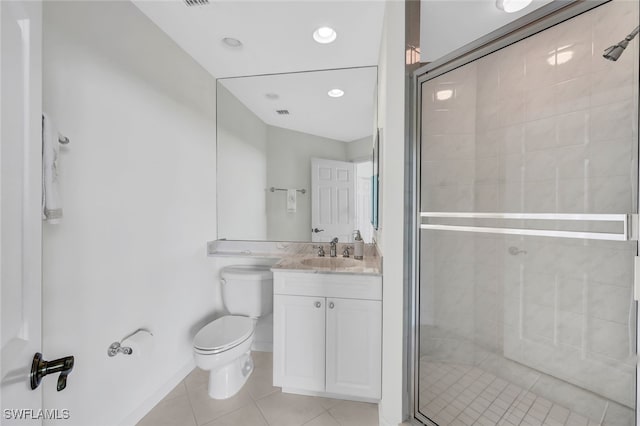 bathroom featuring toilet, a shower with shower door, vanity, and tile patterned flooring