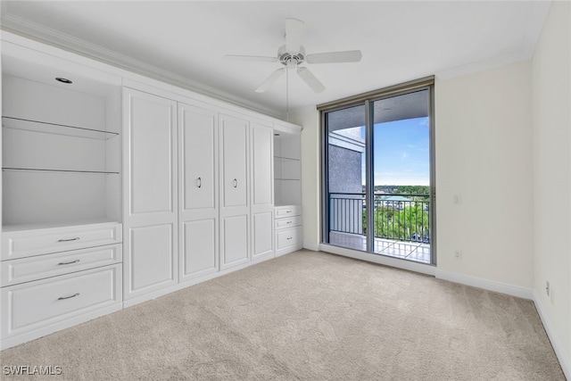 unfurnished bedroom featuring access to exterior, a closet, ceiling fan, light carpet, and crown molding