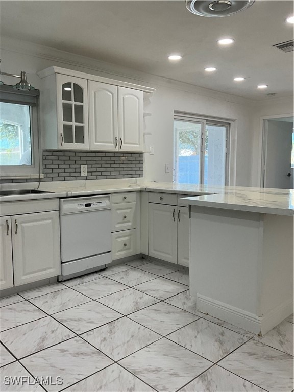 kitchen with white cabinetry, decorative backsplash, white dishwasher, and crown molding