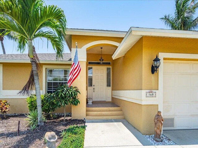 160 Kirkwood St, Marco Island, FL 34145 - entrance to property featuring an attached garage and stucco siding