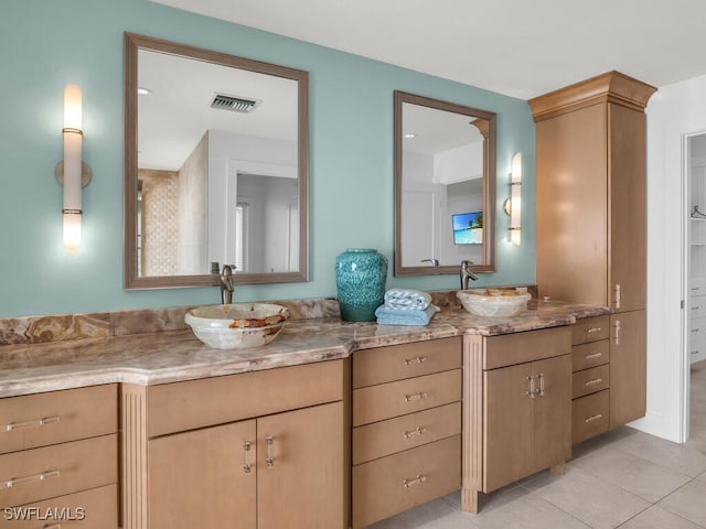full bath with double vanity, visible vents, tile patterned flooring, and a sink