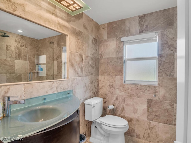 full bath with toilet, tile walls, a shower, and vanity