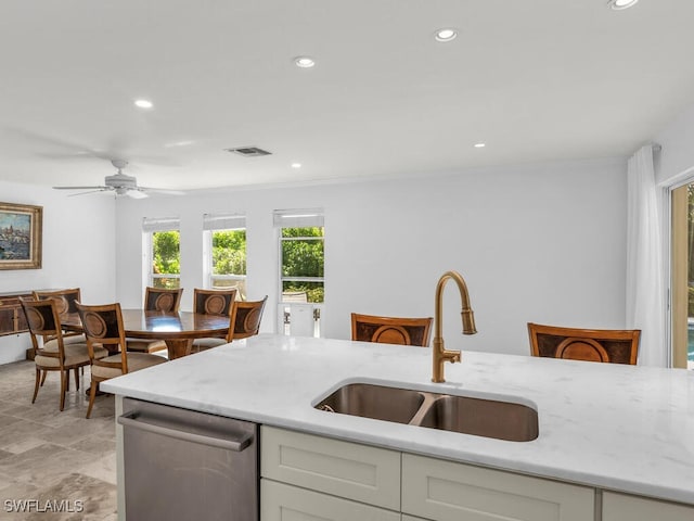kitchen featuring light stone counters, dishwasher, recessed lighting, and a sink