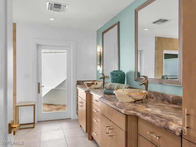 full bath featuring double vanity, visible vents, and a sink
