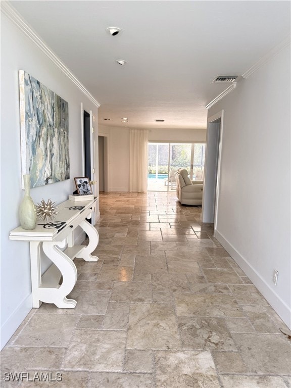 hall featuring ornamental molding, visible vents, stone finish floor, and baseboards
