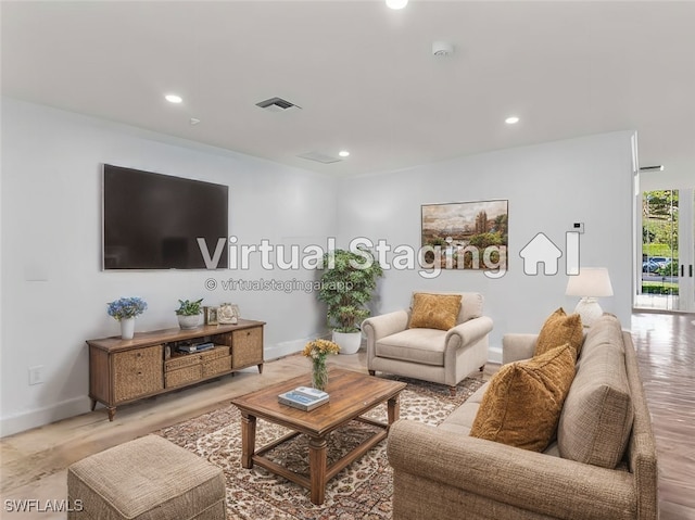 living room featuring baseboards, visible vents, light wood-style floors, and recessed lighting
