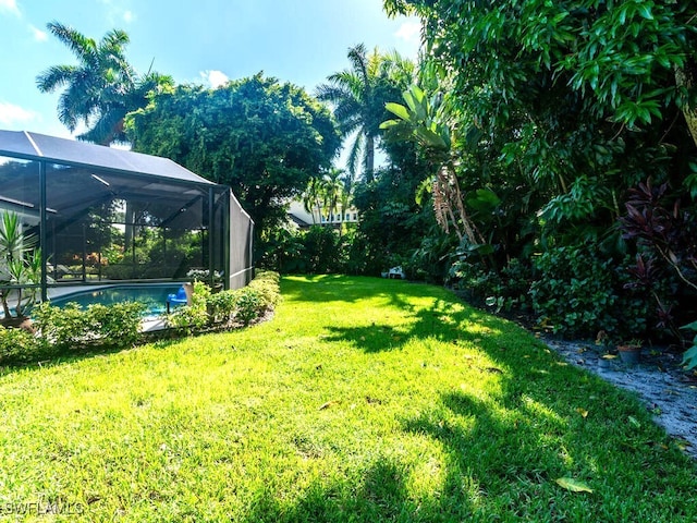 view of yard featuring an outdoor pool and glass enclosure