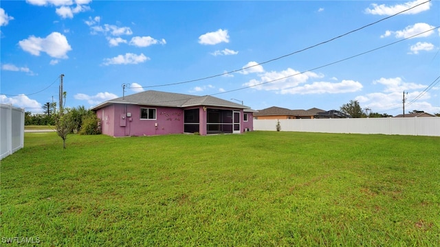 rear view of property with a yard and a sunroom