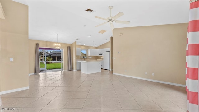 unfurnished living room with high vaulted ceiling, light tile patterned flooring, and ceiling fan with notable chandelier