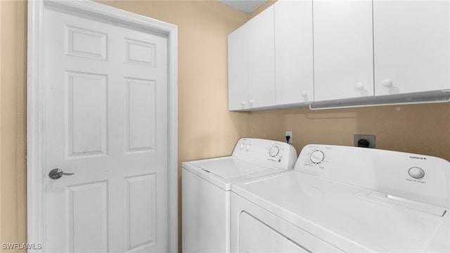 washroom with cabinets and washing machine and clothes dryer