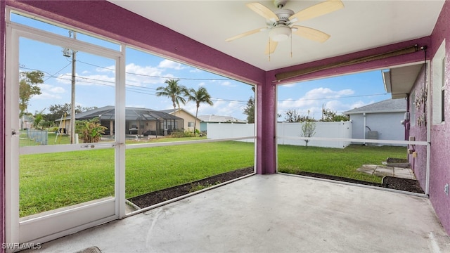 unfurnished sunroom featuring ceiling fan