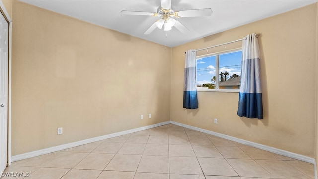 tiled empty room featuring ceiling fan