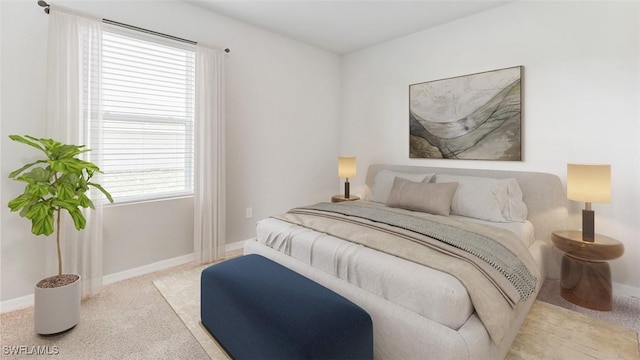 bedroom featuring light carpet and baseboards