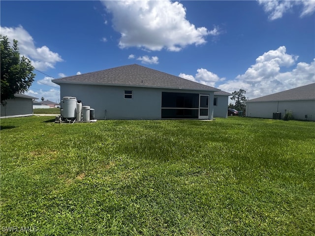 back of house with a lawn and central AC unit