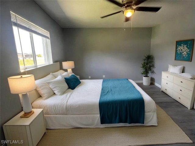 bedroom with dark hardwood / wood-style flooring and ceiling fan