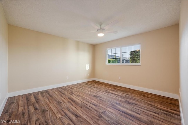unfurnished room with baseboards, a ceiling fan, and dark wood finished floors
