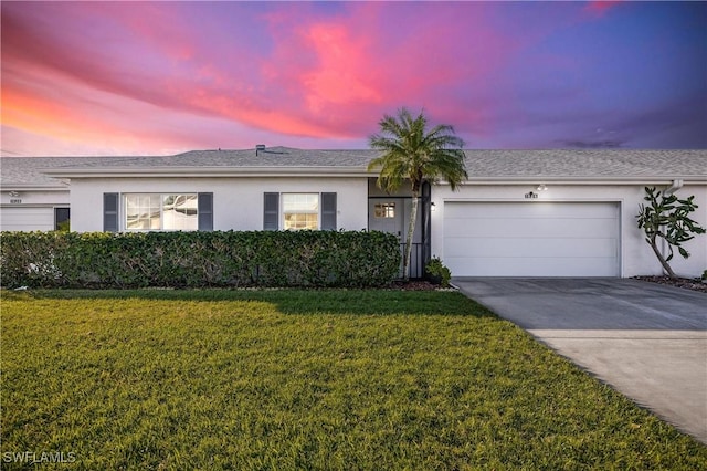 single story home featuring a front yard, an attached garage, driveway, and stucco siding