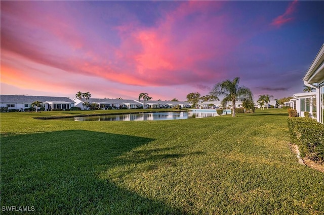 view of yard with a residential view and a water view