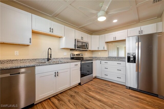 kitchen with ceiling fan, a sink, white cabinetry, and stainless steel appliances