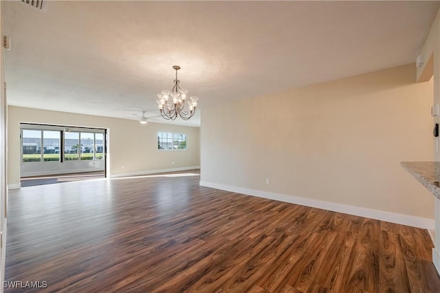 unfurnished dining area with a notable chandelier, baseboards, visible vents, and dark wood finished floors