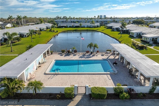 pool featuring a residential view, a patio area, fence, and a water view