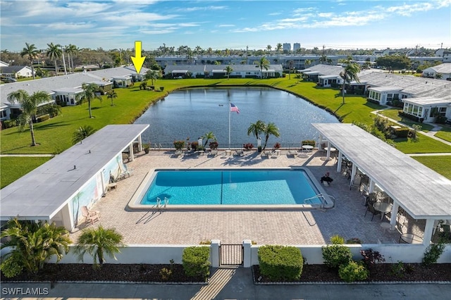 community pool with a patio, a residential view, fence, and a water view
