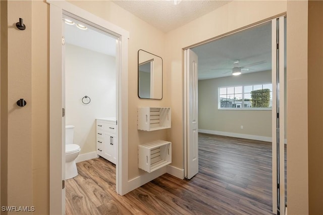 hallway featuring baseboards and wood finished floors