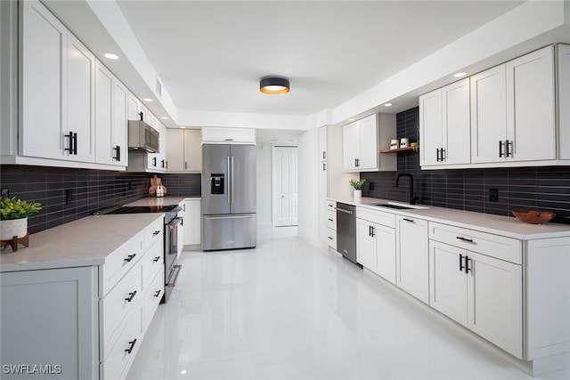 kitchen featuring tasteful backsplash, stainless steel appliances, sink, and white cabinets