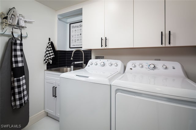 washroom with cabinets, sink, and washing machine and clothes dryer