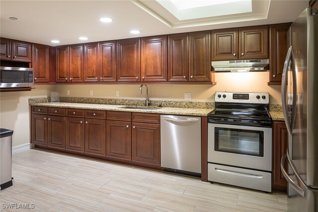 kitchen featuring sink, light stone countertops, and appliances with stainless steel finishes