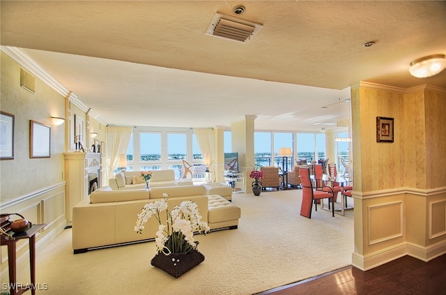 living room with crown molding, hardwood / wood-style floors, a textured ceiling, and plenty of natural light