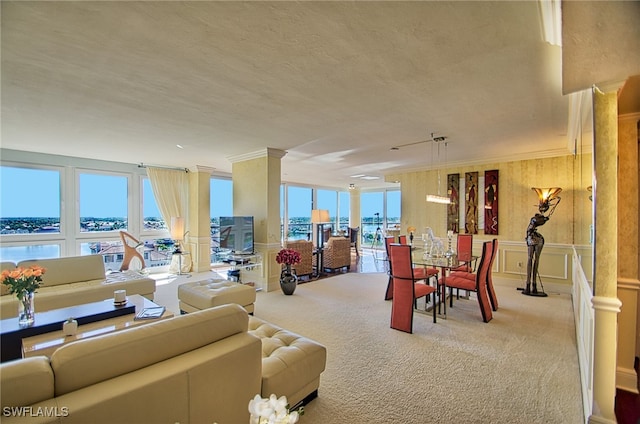 carpeted living room with a water view, a healthy amount of sunlight, and ornamental molding