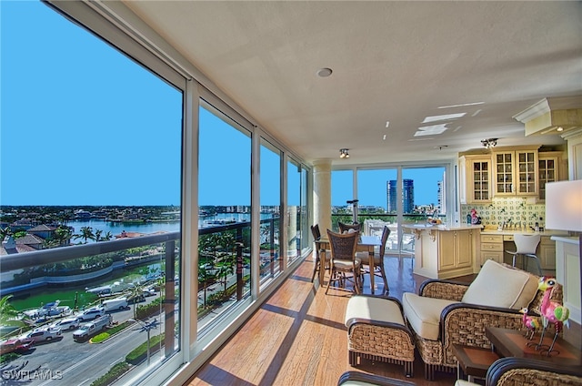 sunroom featuring a water view