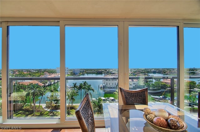 sunroom / solarium featuring a water view and plenty of natural light