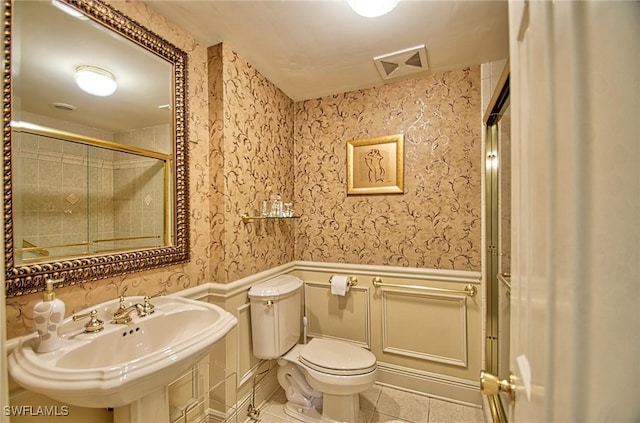 4031 Gulf Shore Blvd N Unit 8E, Naples, FL 34103 - bathroom with visible vents, wainscoting, toilet, tile patterned floors, and a sink