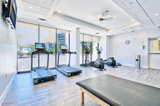 4031 Gulf Shore Blvd N Unit 8E, Naples, FL 34103 - exercise room featuring baseboards, a ceiling fan, a tray ceiling, and wood finished floors