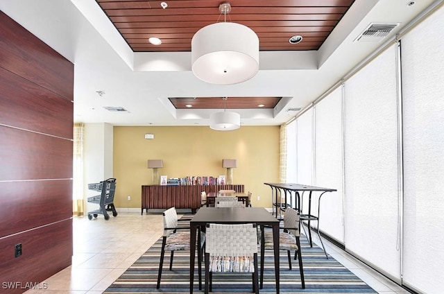 dining area featuring light tile patterned flooring, wooden ceiling, and a tray ceiling