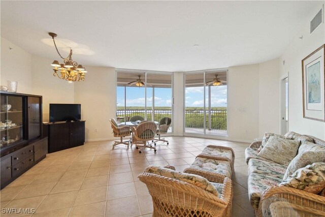 living room with a chandelier, expansive windows, and light tile patterned floors