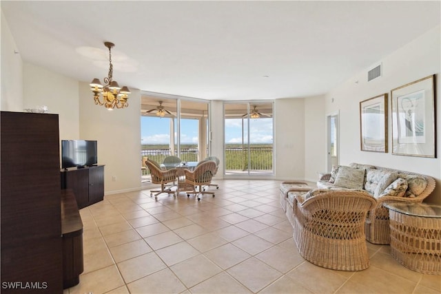 living room featuring ceiling fan with notable chandelier and light tile patterned flooring